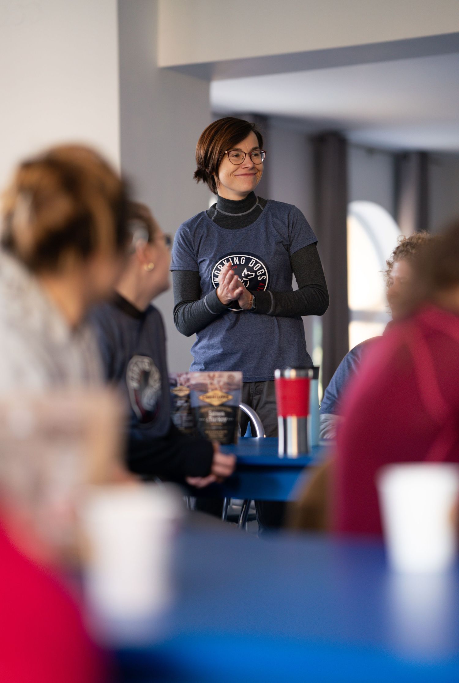 Presenter holding a mug while speaking to an attentive audience at a conference.