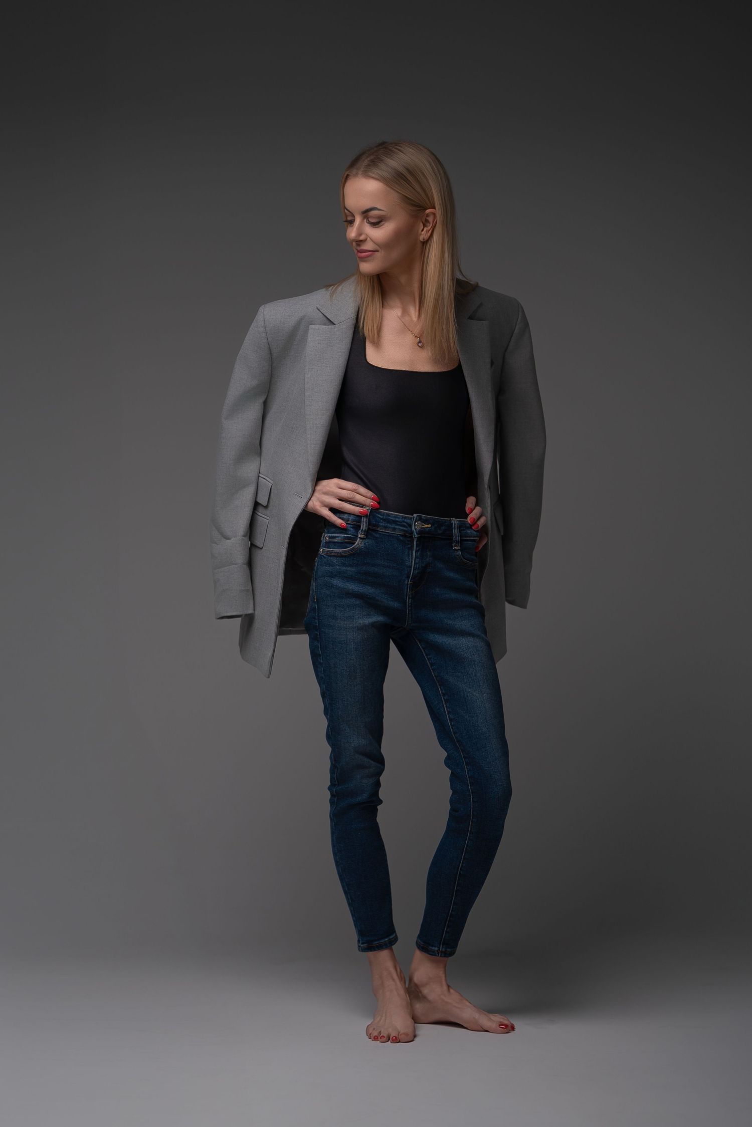 Professional fashion photo series showing a grey blazer and jeans outfit styled in different poses against dark background.