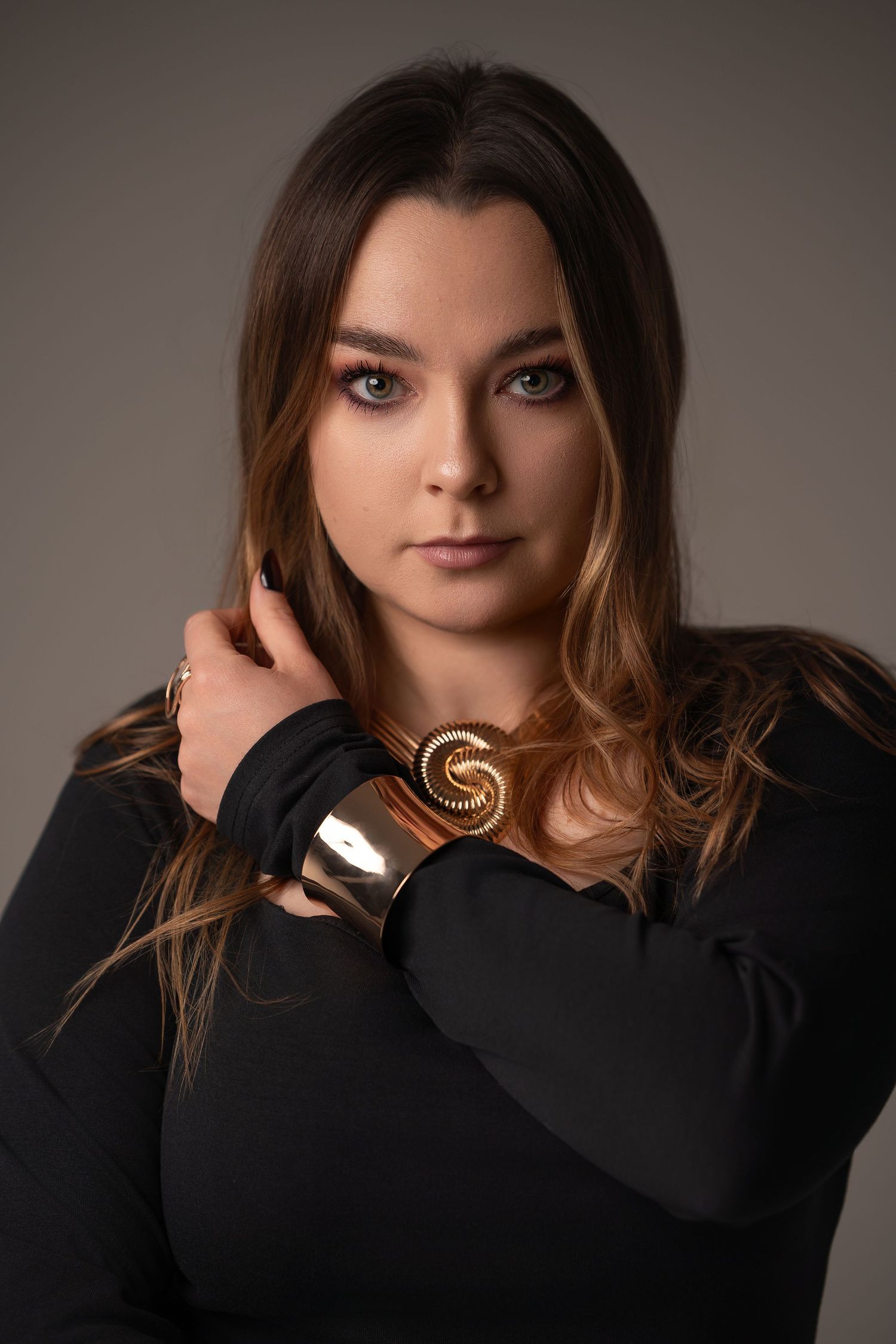 A series of dramatic portrait shots showing a model in a black sweater against a neutral background.