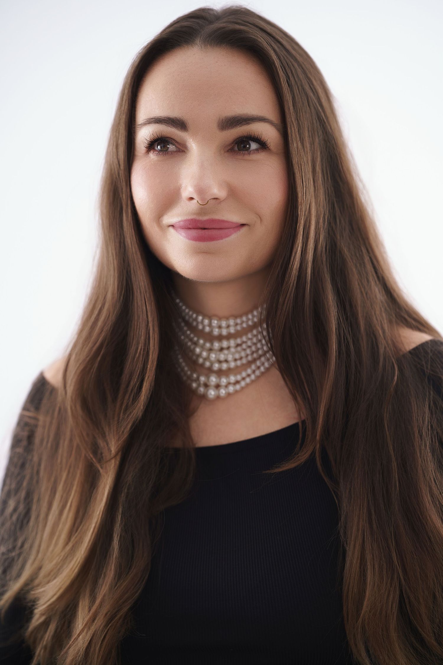 A woman in a black top and pearl choker necklace poses in a series of similar headshots against a white background.