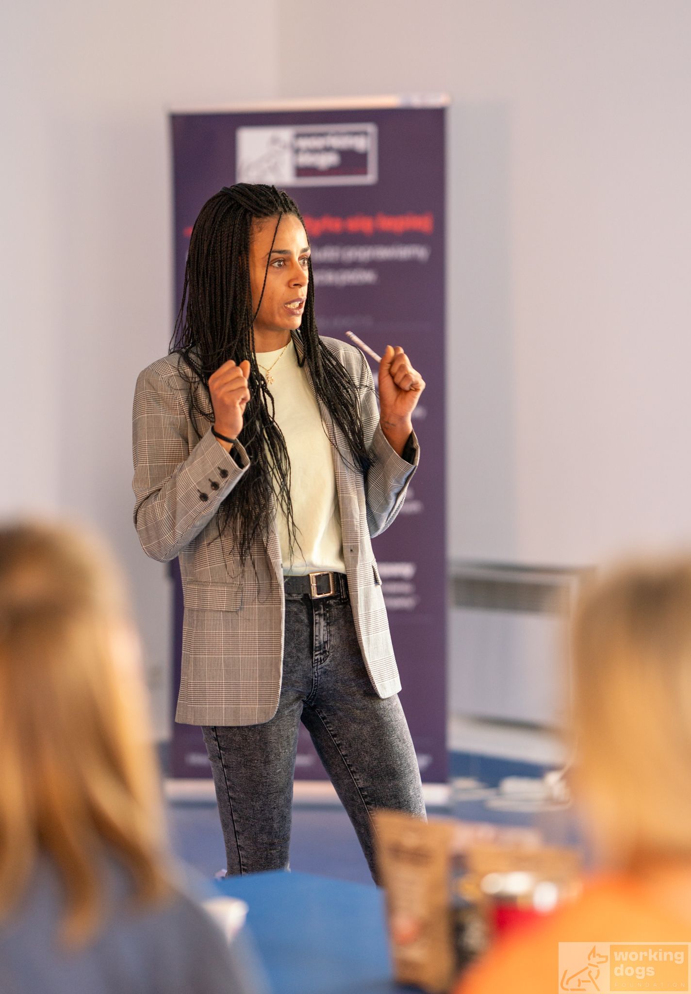 Professional speaker giving a presentation wearing a gray blazer and white top.