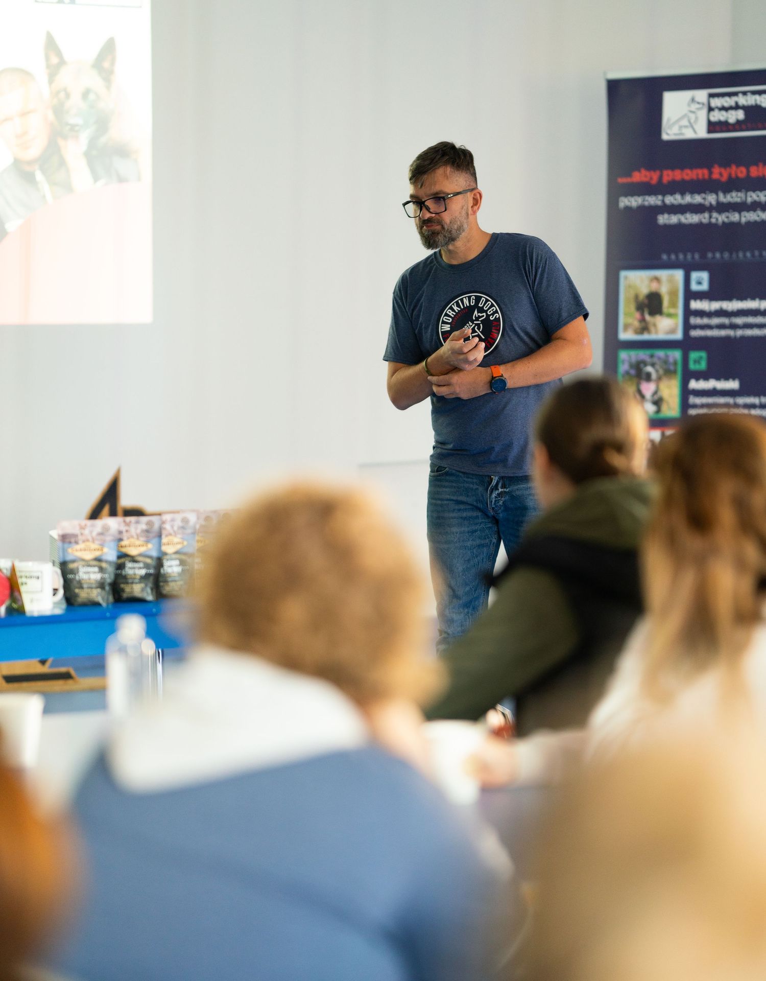 Speaker giving an educational presentation to an audience in a classroom setting.