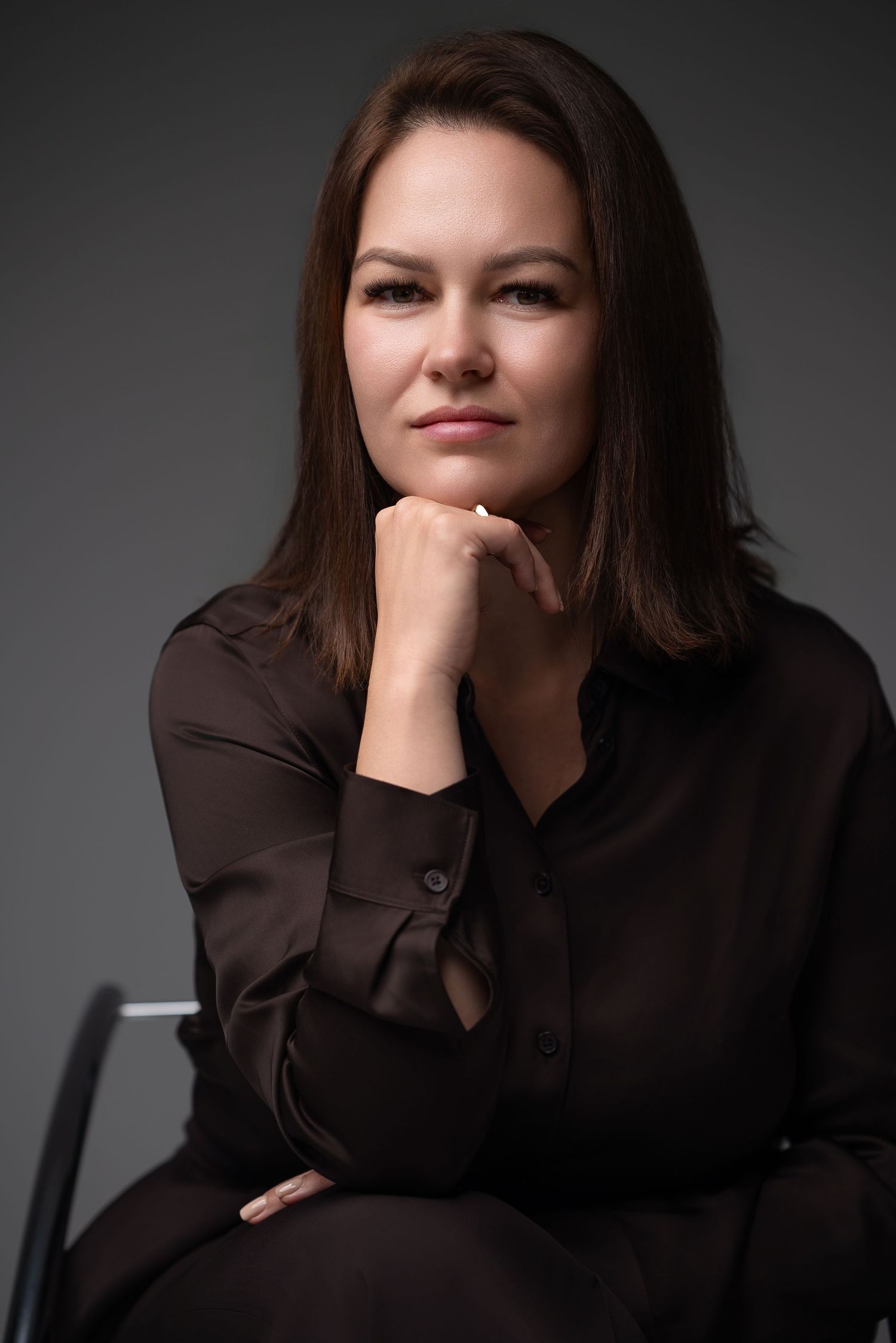 A series of dramatic black and white portraits showing someone in a dark shirt against a gray background.