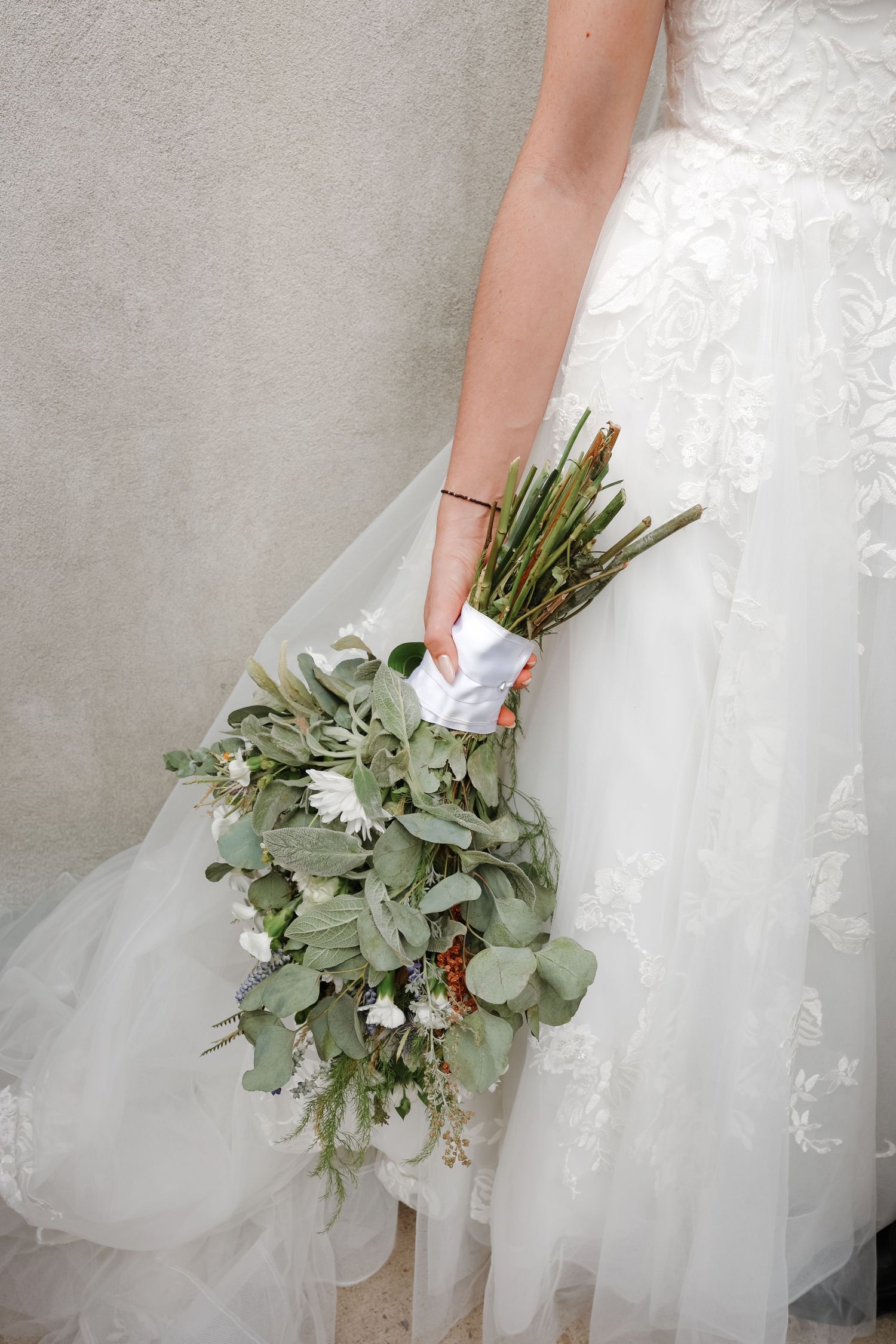 Bride holding a bouquet of greenery and florals on her wedding day in Utah