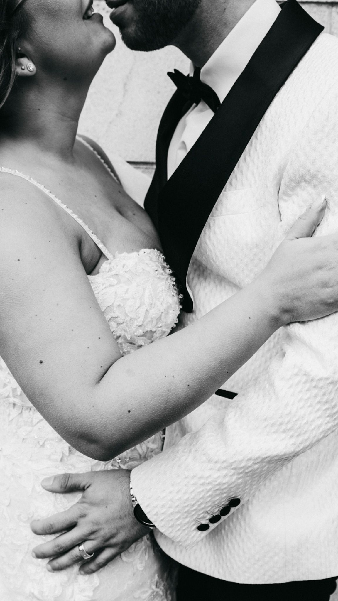 Intimate black and white close-up of newlywed couple about to kiss.