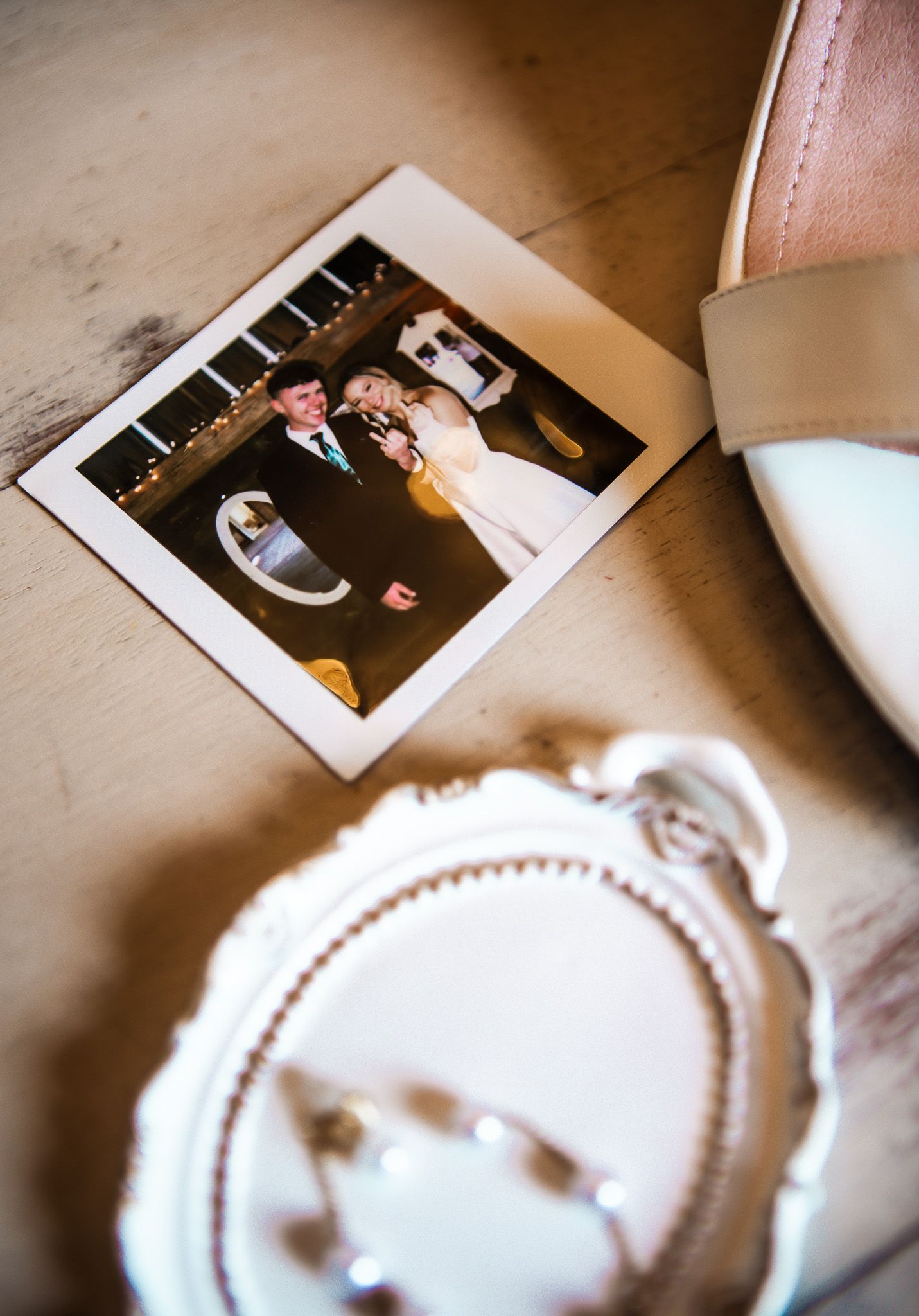 A vintage-style polaroid photo next to a white bridal shoe.