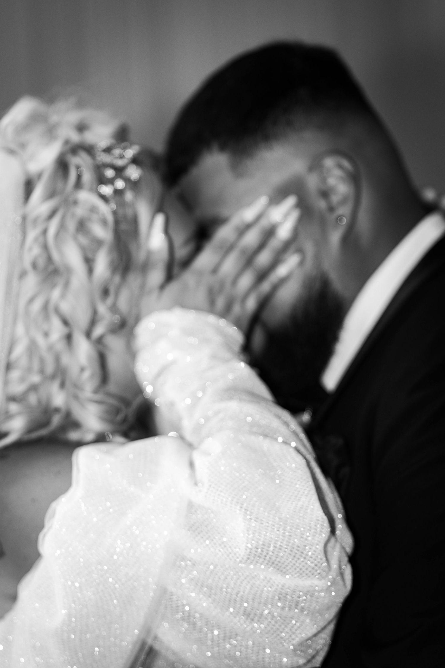 Intimate black and white wedding moment captured with bride in sparkly dress.