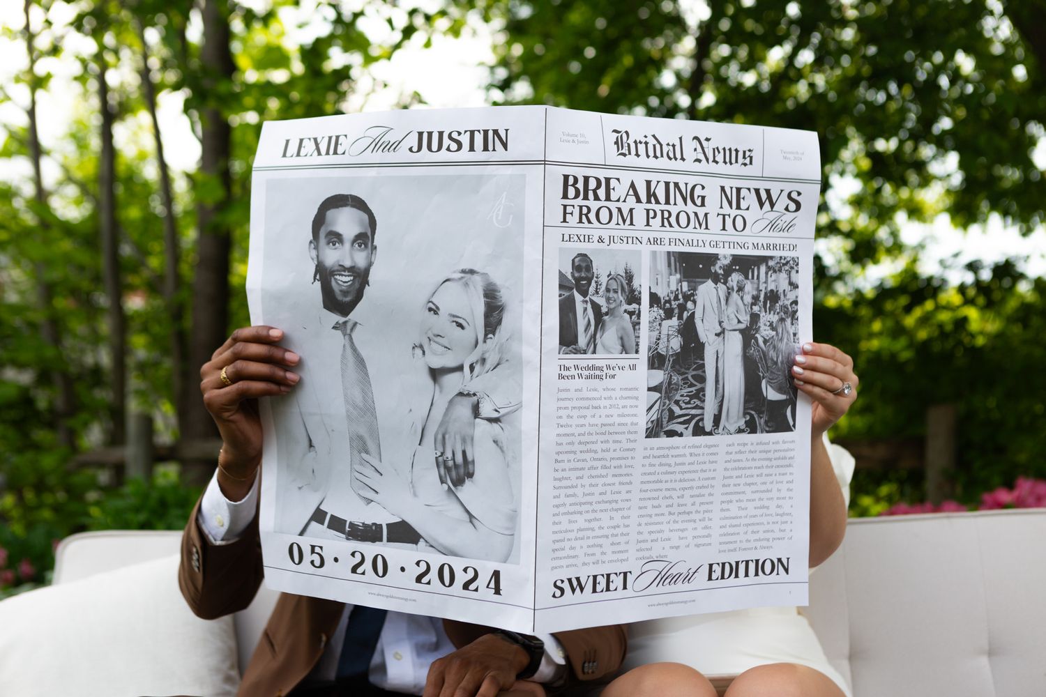 A custom wedding newspaper announcement being held up outdoors.