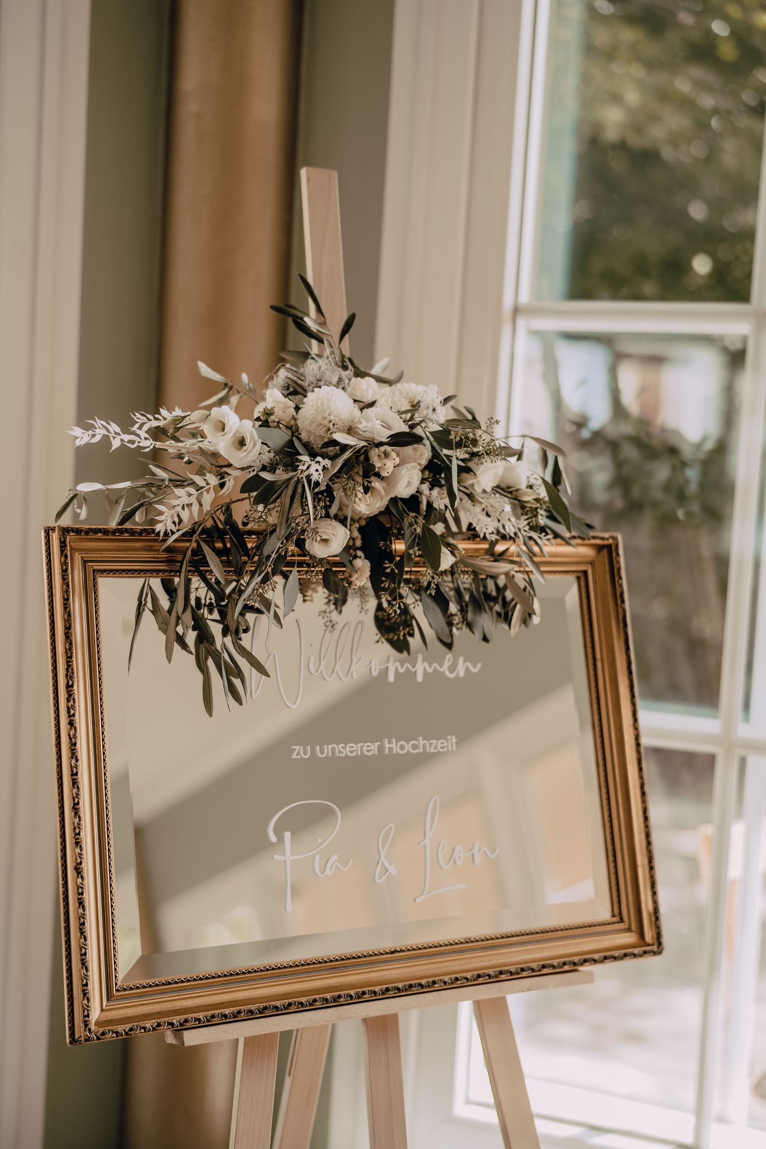 Decorative framed signs adorned with flowers and greenery hang in a row against beige walls.