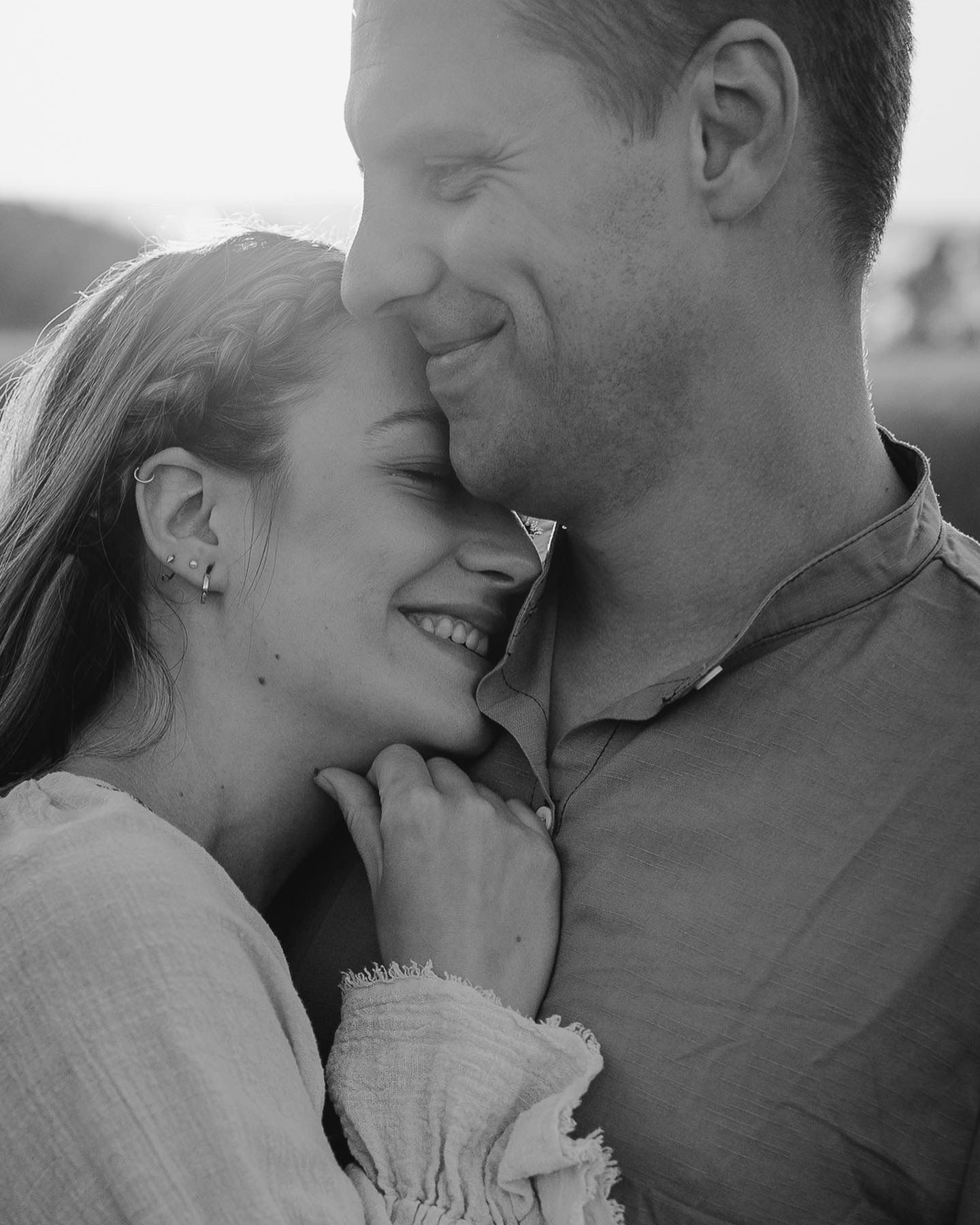 Black and white romantic photo series showing a couple sharing intimate moments and kisses.