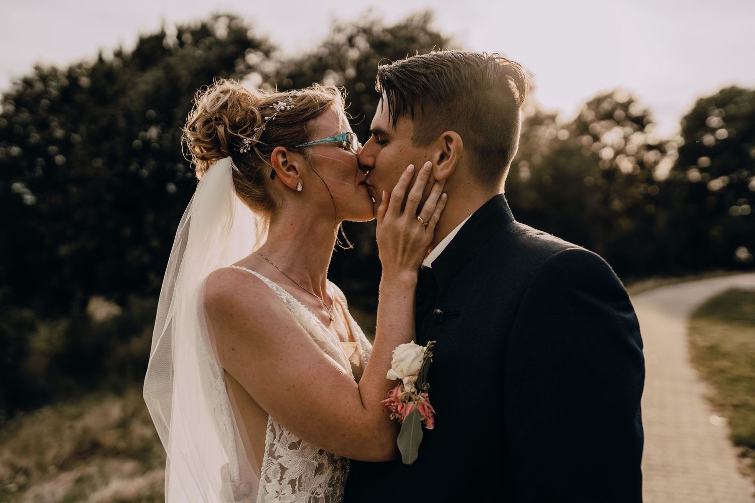 Romantic wedding couple sharing intimate moments at sunset in a golden outdoor setting.