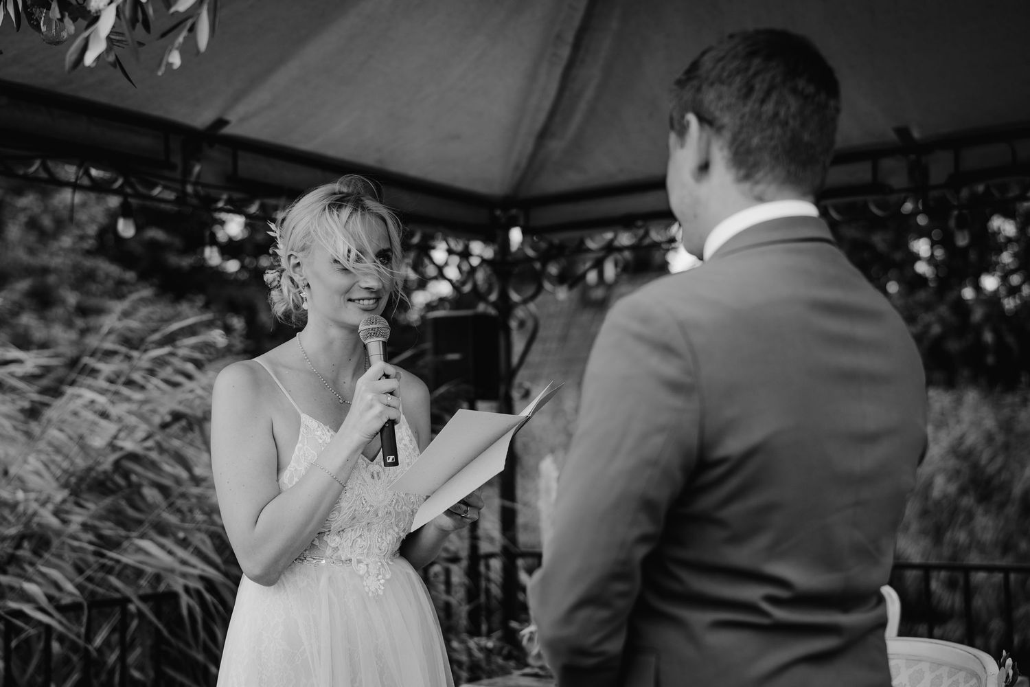 Black and white candid moment from an outdoor wedding celebration.