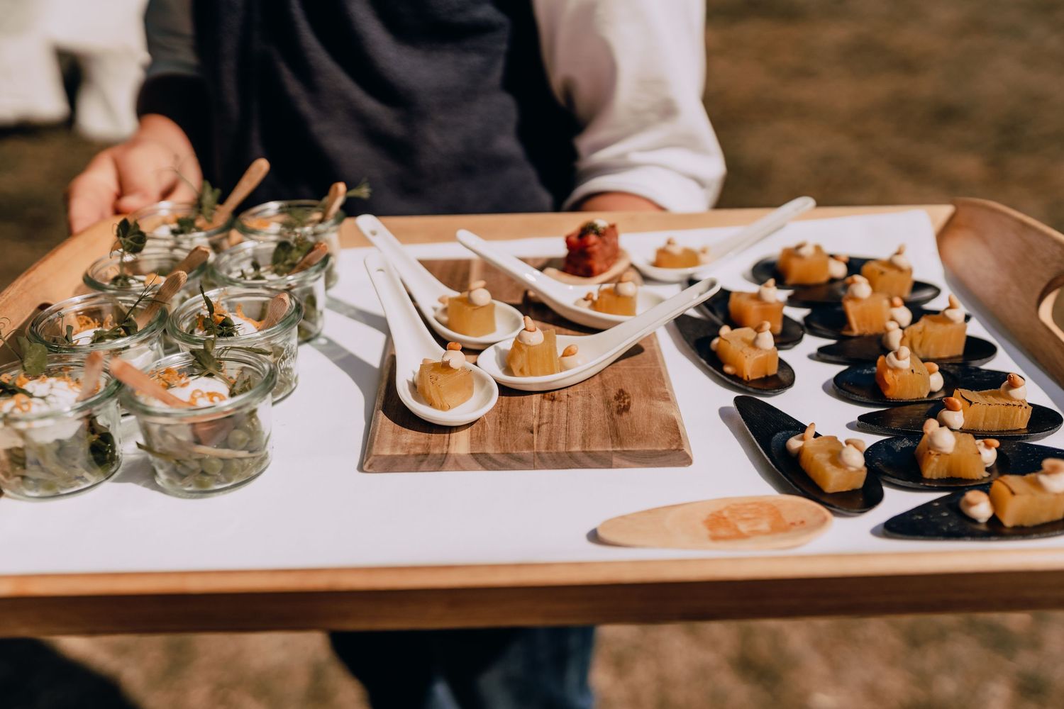 Elegant appetizers and hors d'oeuvres arranged on wooden serving boards at wedding reception.