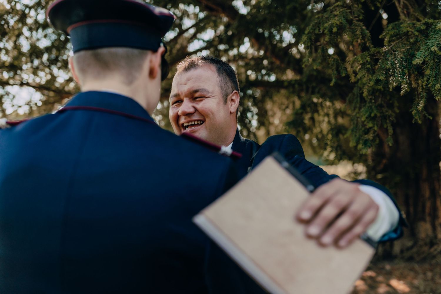 Wedding guests gathered outdoors during a ceremony in a natural garden setting.