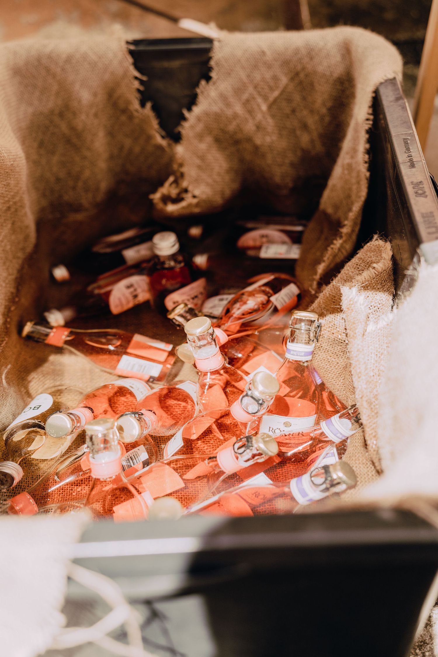 Wedding favors and small gifts scattered in a decorative basket with coral and pink tones.