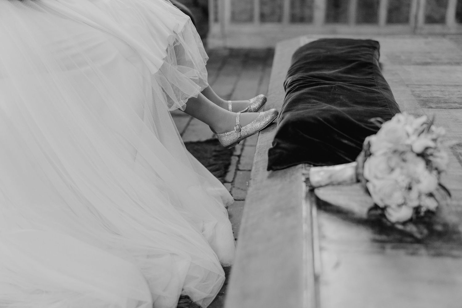 Wedding couple walking hand in hand through a rustic wooden barn doorway.