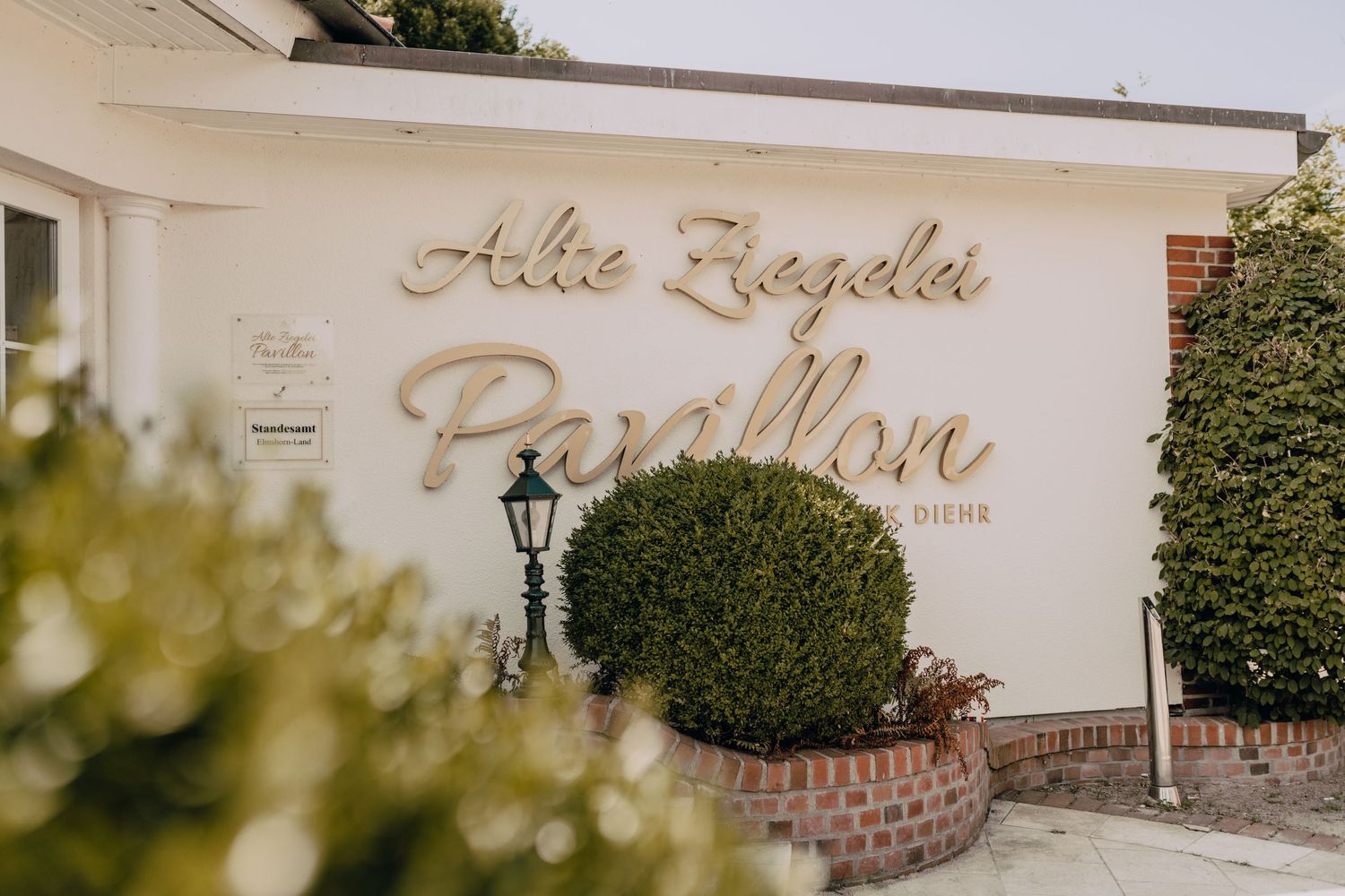 Elegant venue exterior with manicured landscaping and classic white architectural details.