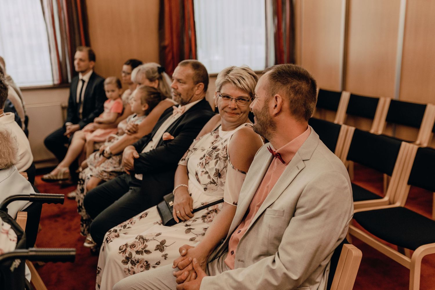 Wedding guests seated in rows of chairs during ceremony.