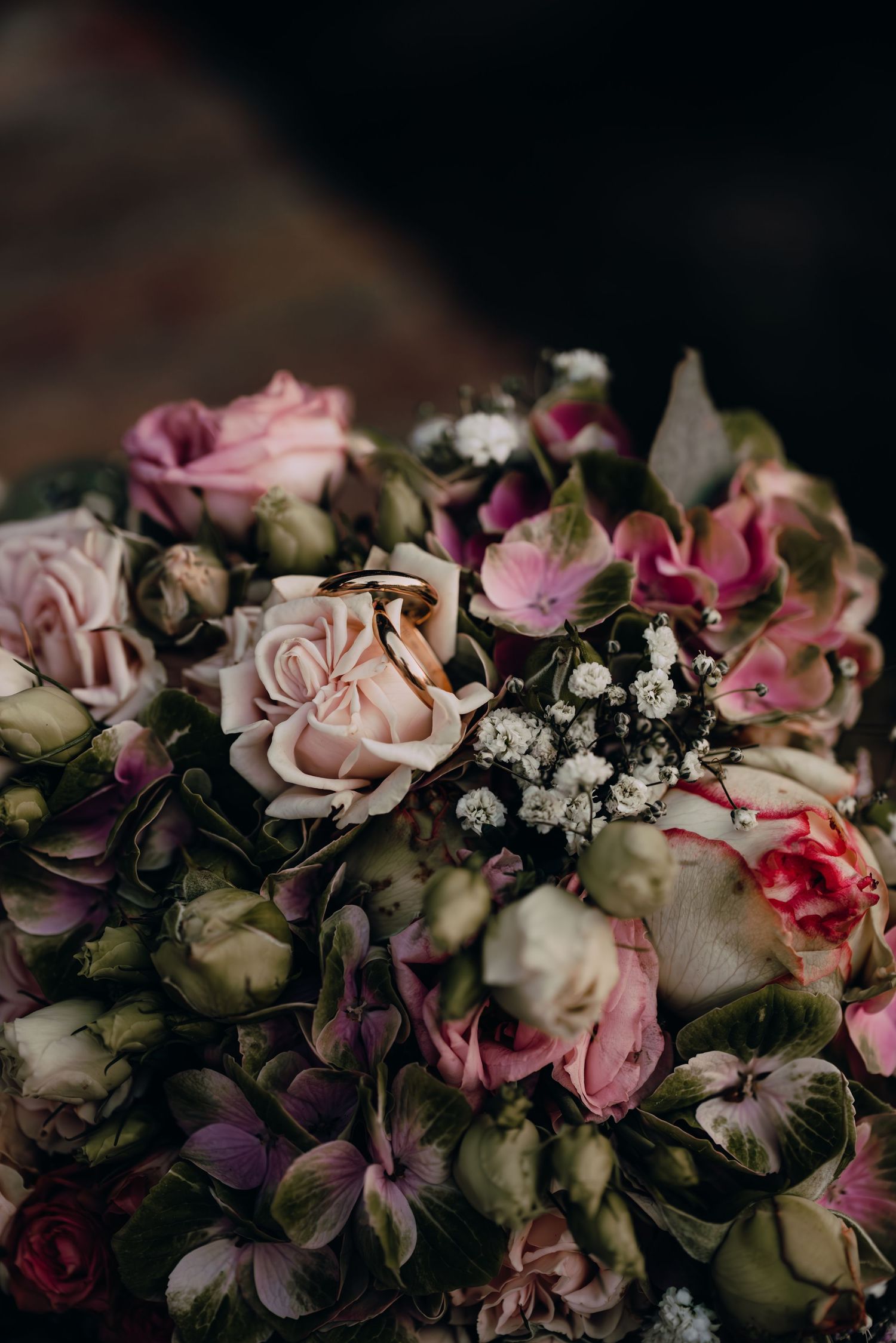 Stunning wedding bouquet with pink roses and mixed flowers in romantic lighting.