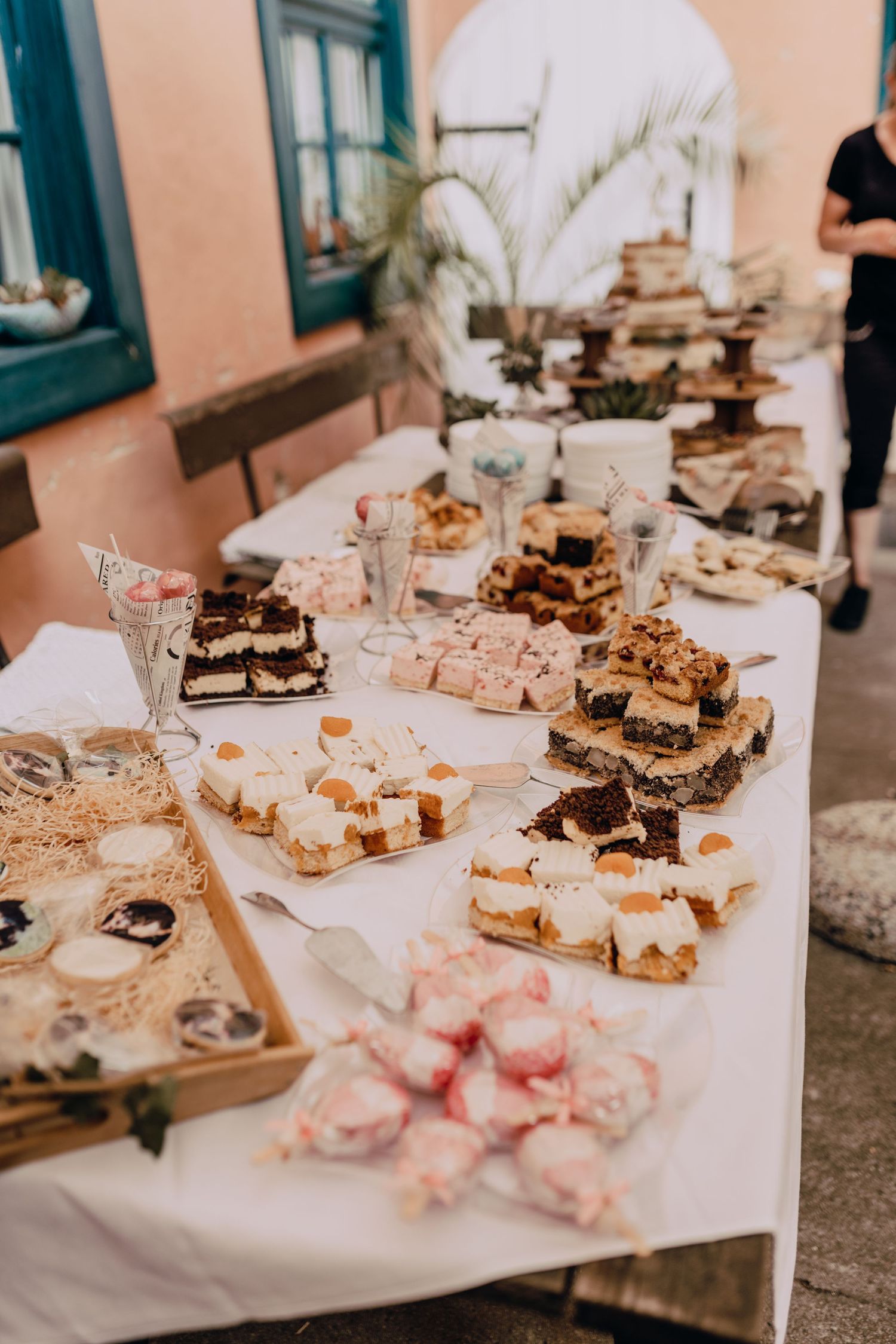 Wedding dessert table filled with elegant pastries and treats displayed on a white tablecloth.
