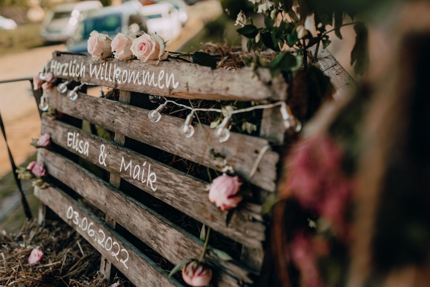 Rustic wooden logs decorated with small roses and floral arrangements.