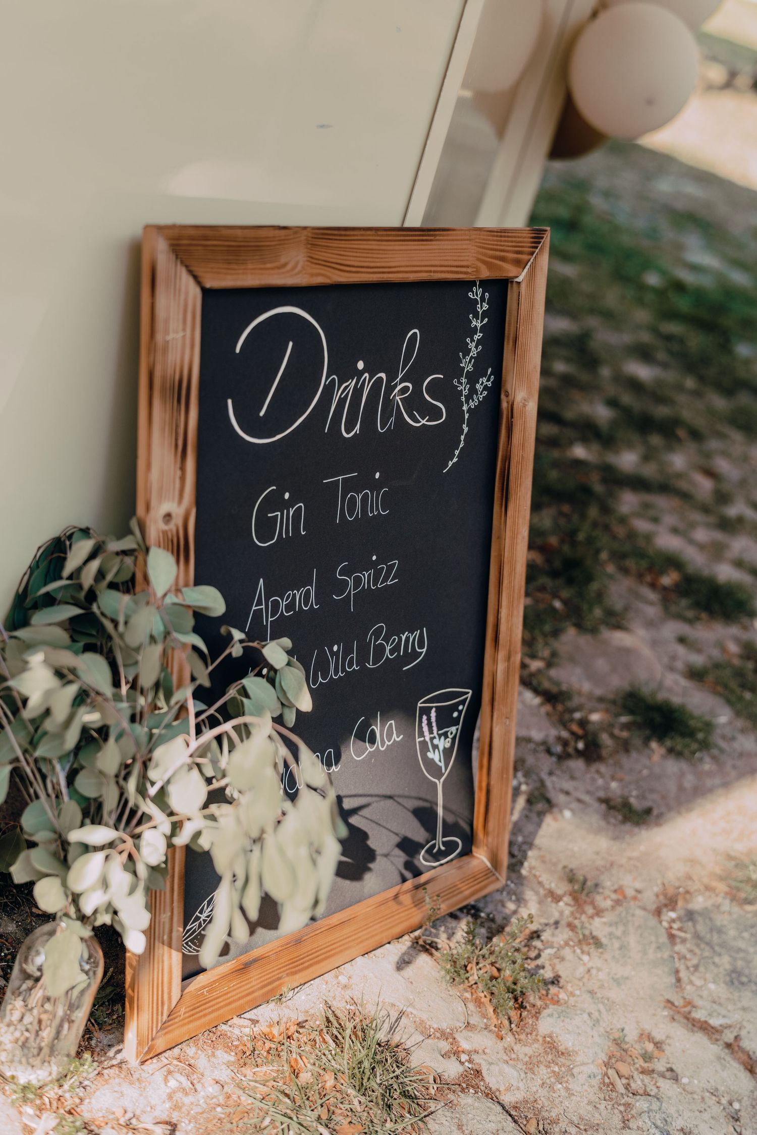 Rustic framed chalkboard menu displaying cocktail options including Gin Tonic and Aperol Spritz.