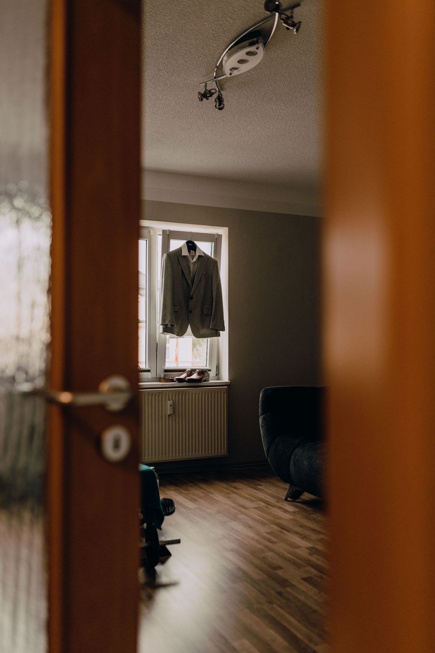 A minimalist room interior with hardwood floors and natural light streaming through windows.