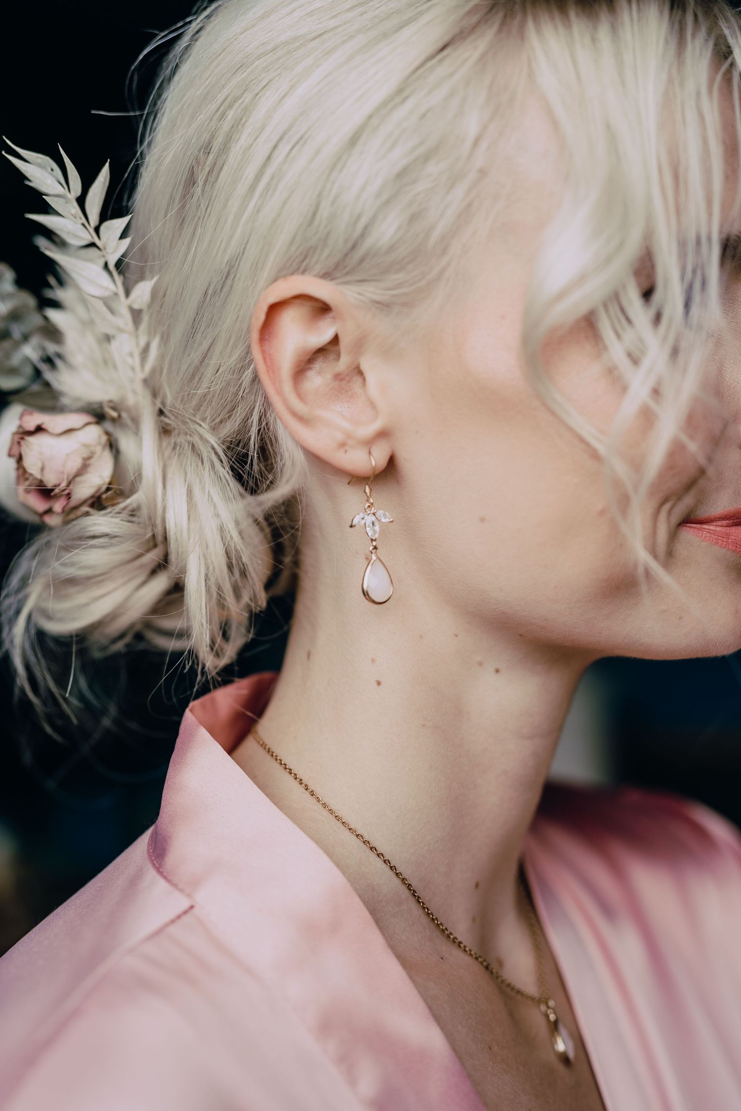 Elegant pearl and crystal hairpiece and earrings styled with a soft pink blouse.