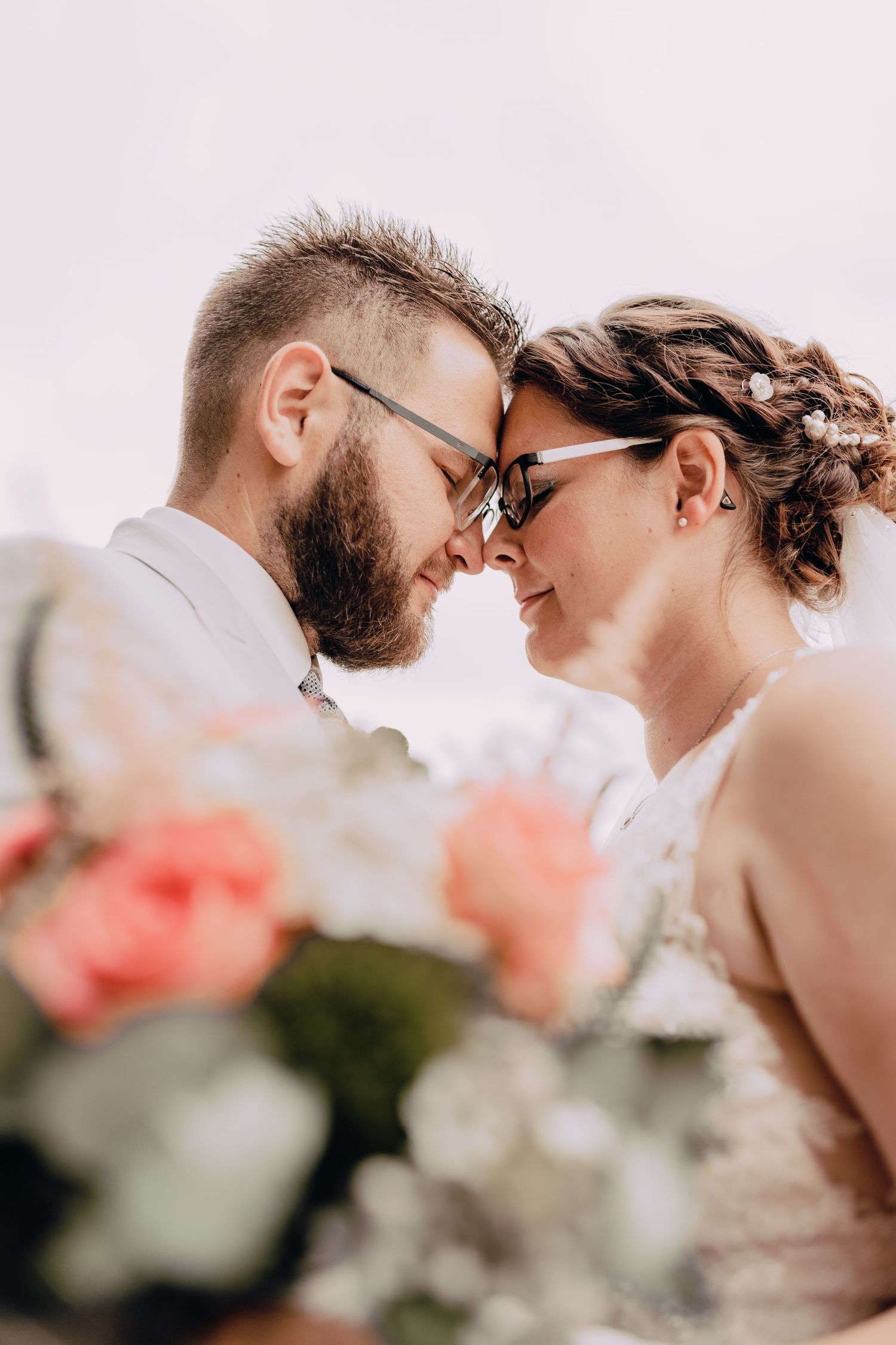 Close up romantic wedding portrait with roses in soft focus.