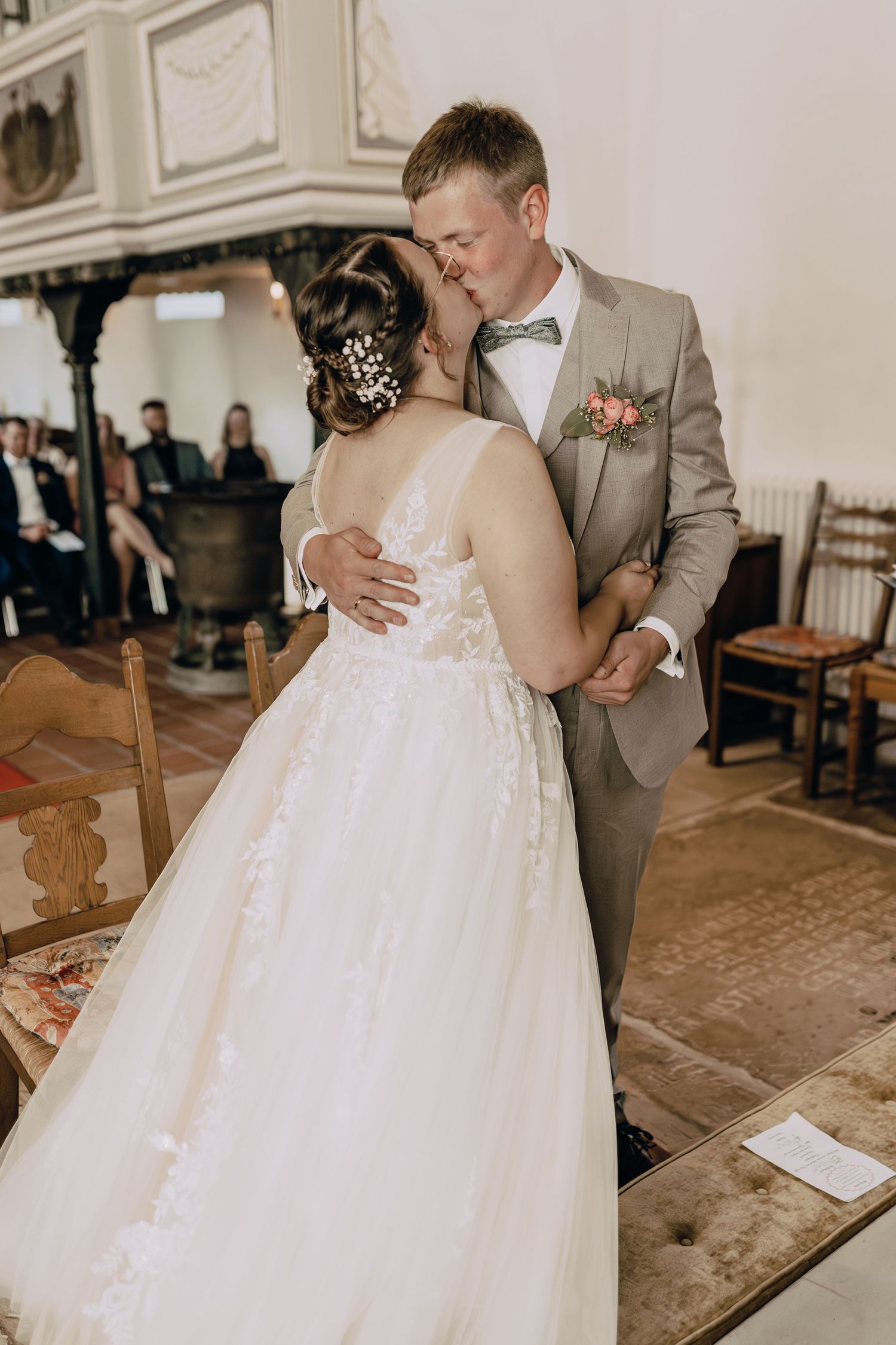 A couple shares an intimate first dance moment at their wedding, with the bride wearing a flowing white gown.