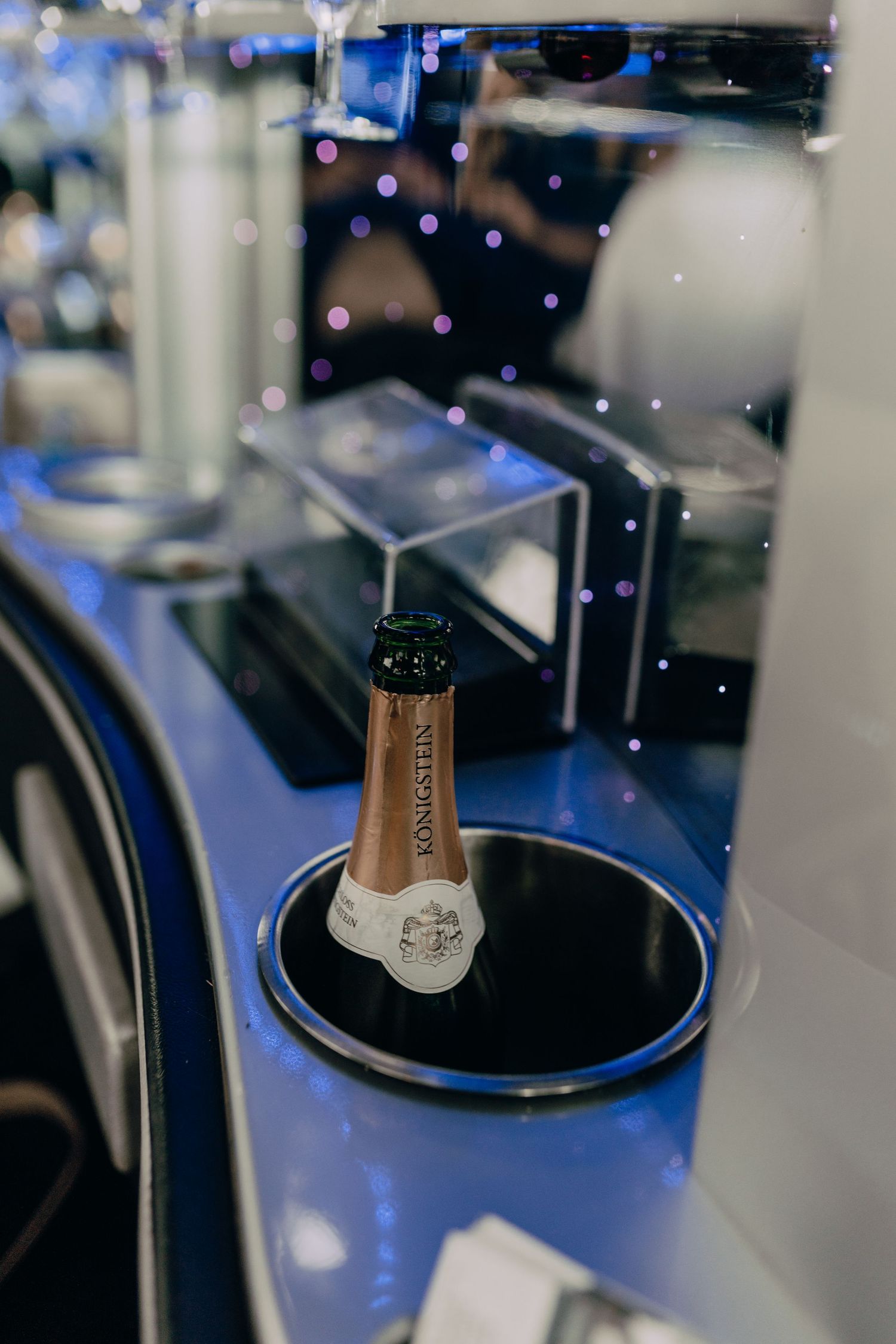 Several close-up shots of champagne bottles being opened in sequence with dark lighting and blue accents.