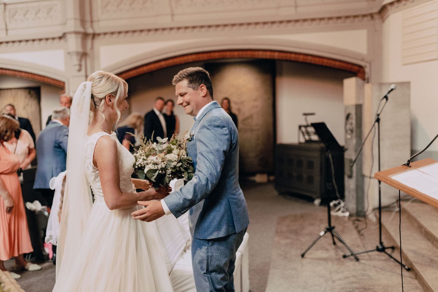 A wedding ceremony moment showing a couple exchanging vows under an arched entryway.