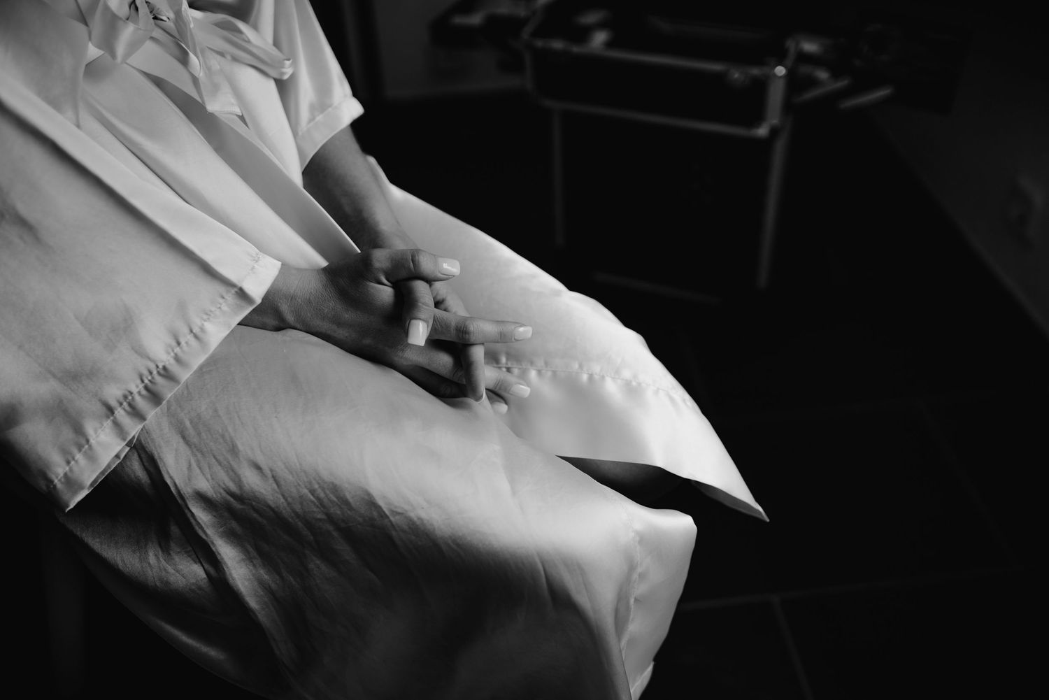A black and white image showing medical professional's gloved hands holding documents or papers.