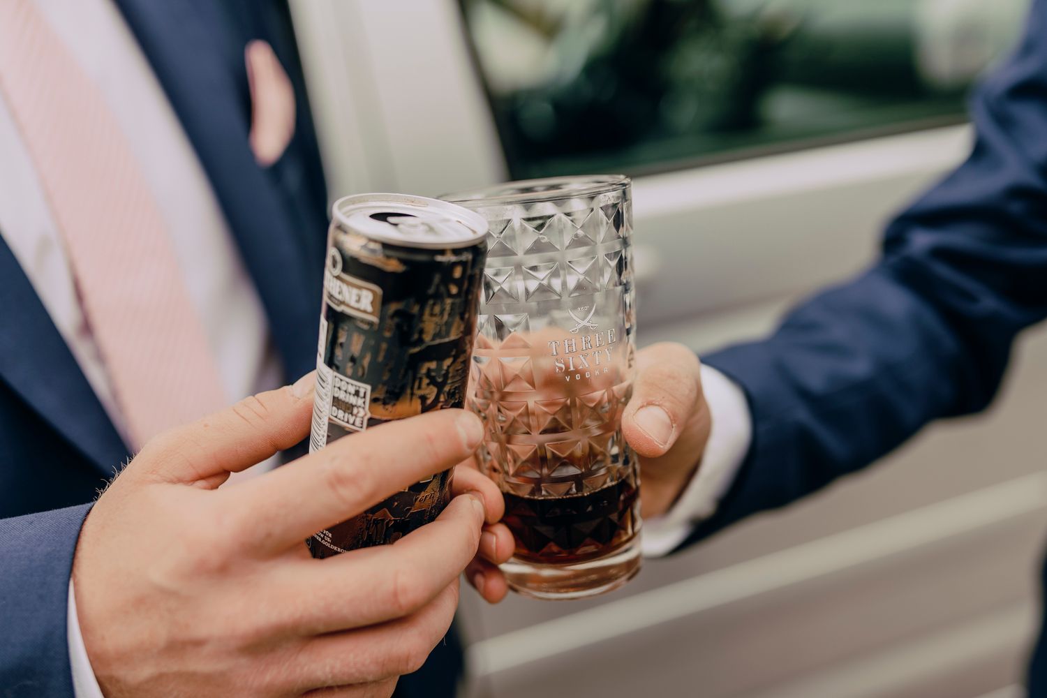 Person holding glass mason jars filled with cold brew coffee against a bright window background.