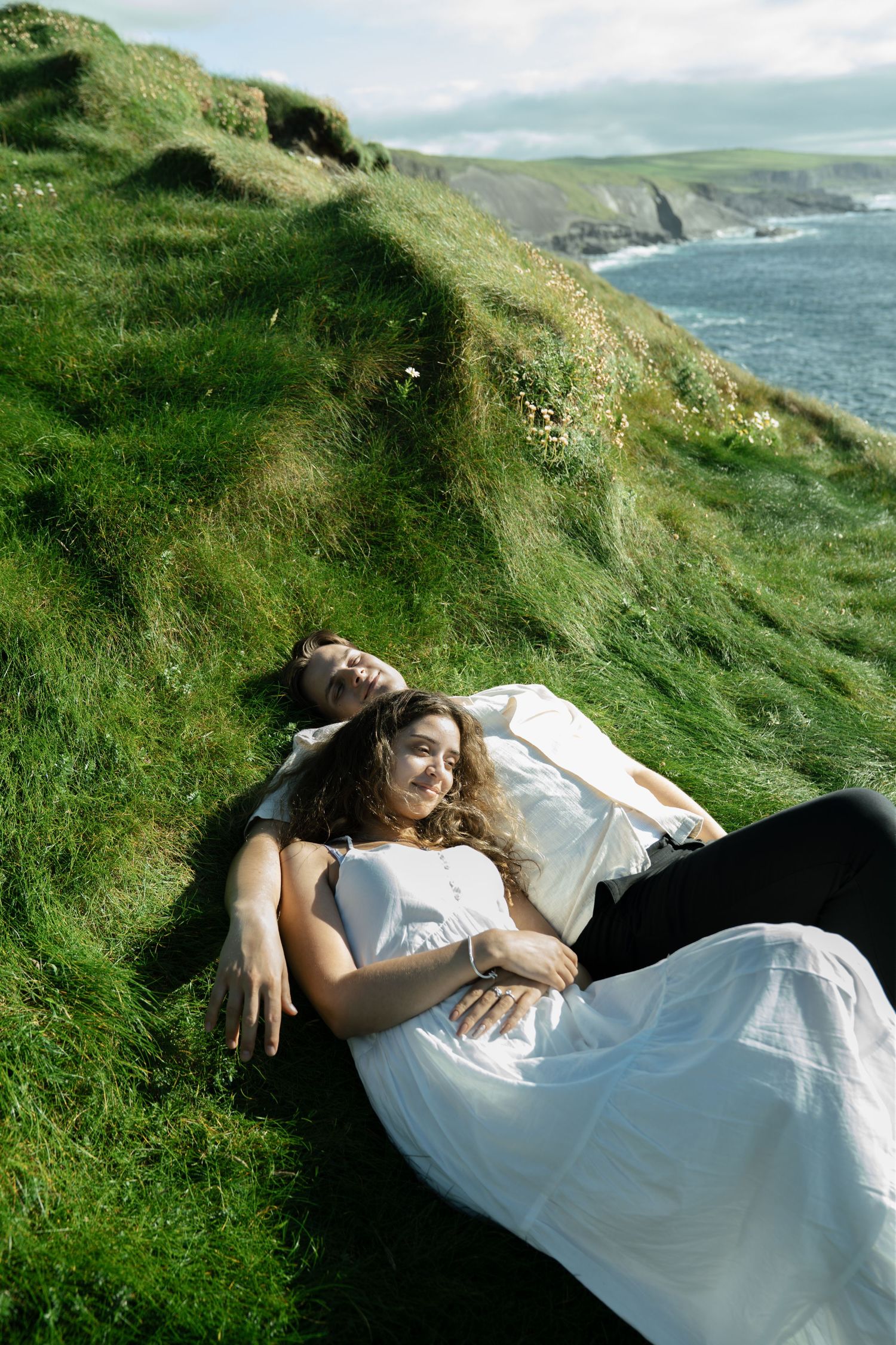 couple laying in the grass at kilkee cliffs