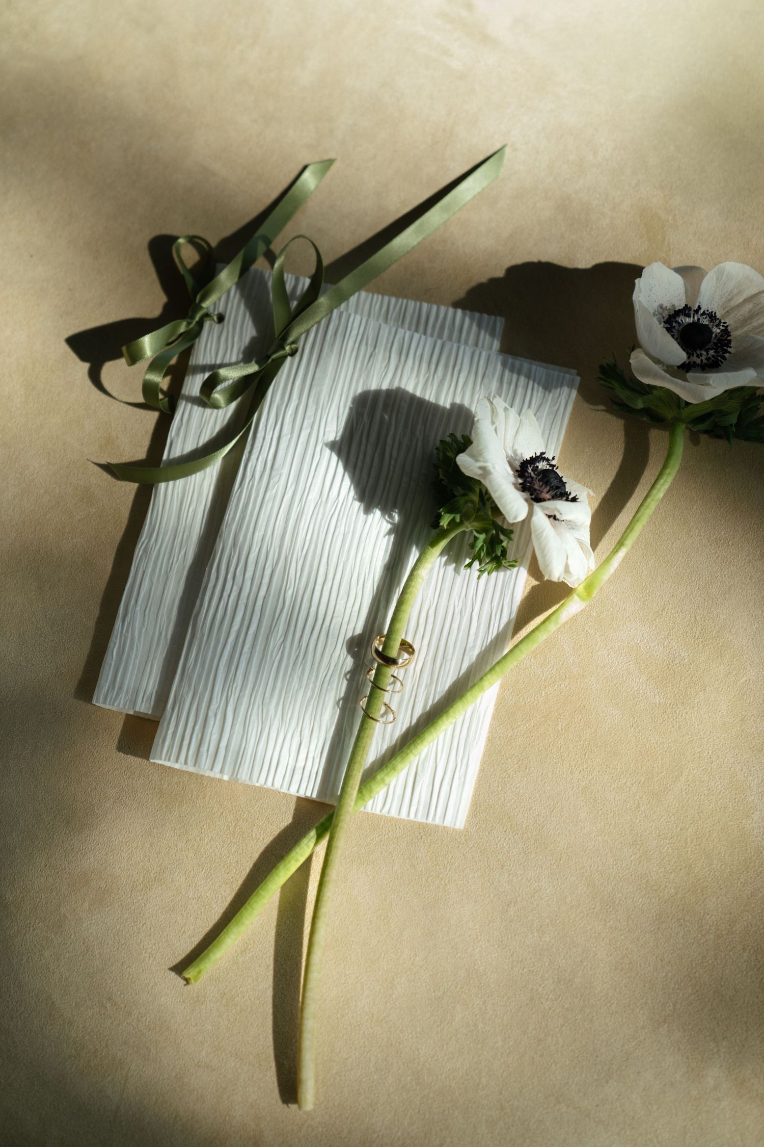artful flat lay with vow books and gold rings
