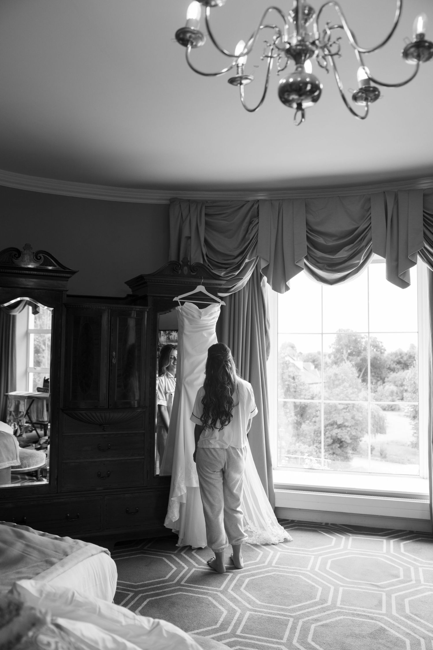 bride fluffing her hanging dress in hotel in ireland