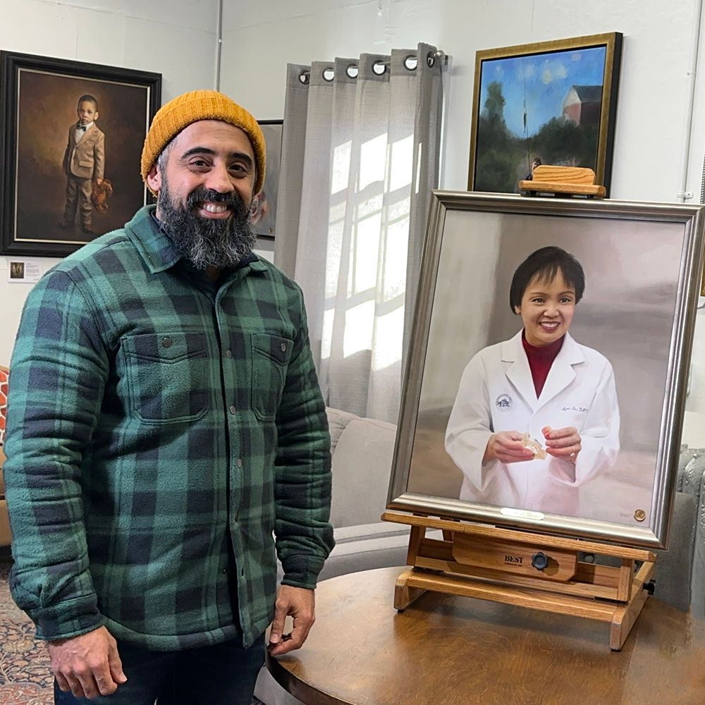 A client proudly standing next to the framed portrait painting he commissioned of his respected mentor. Taken at the unveiling.