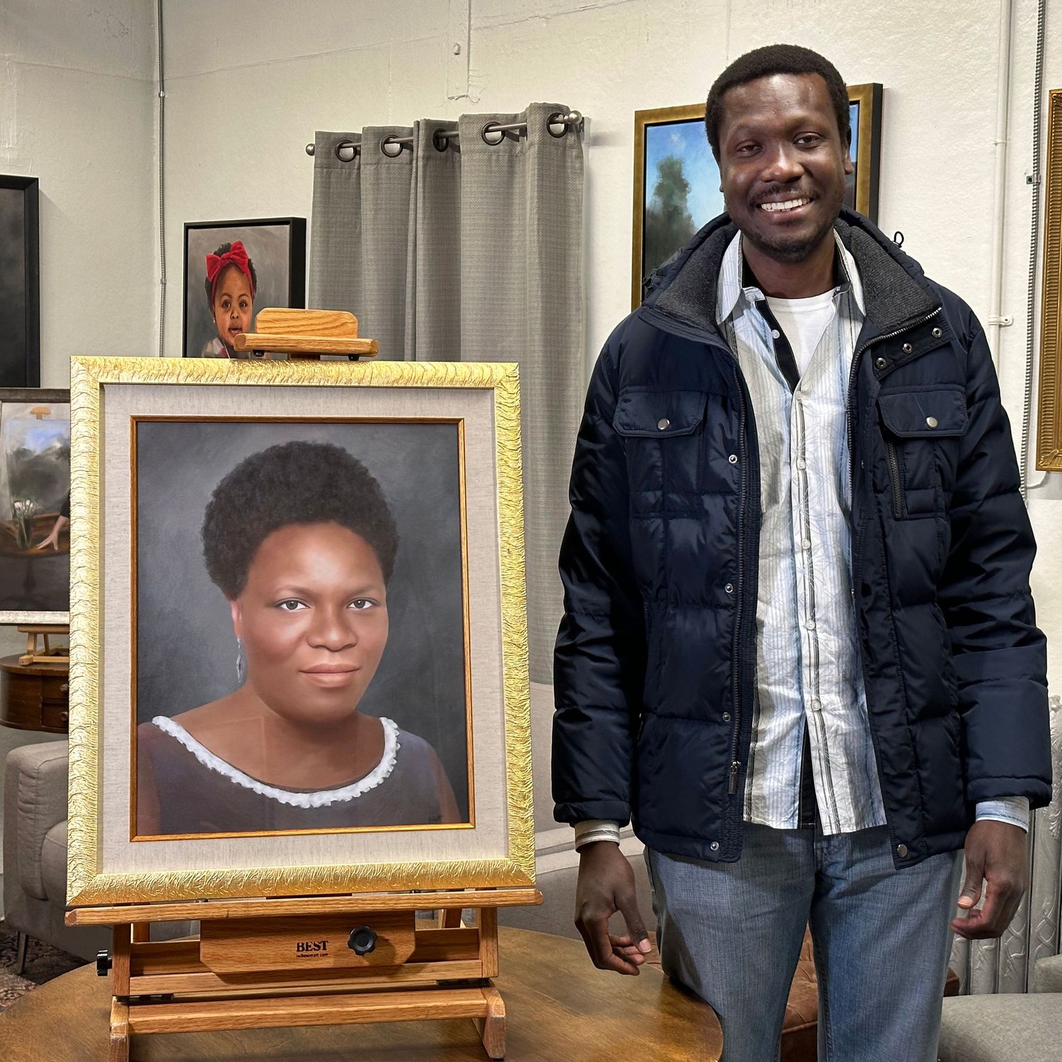 Client at the unveiling, standing beside a memorial painted portrait of his late mother, on an easel in the studio.