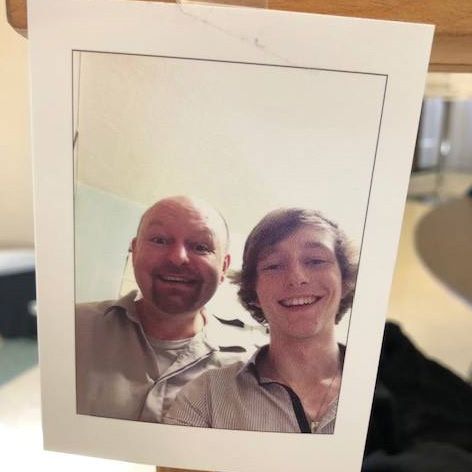 Reference photograph showing a close-up portrait of a father and son together.