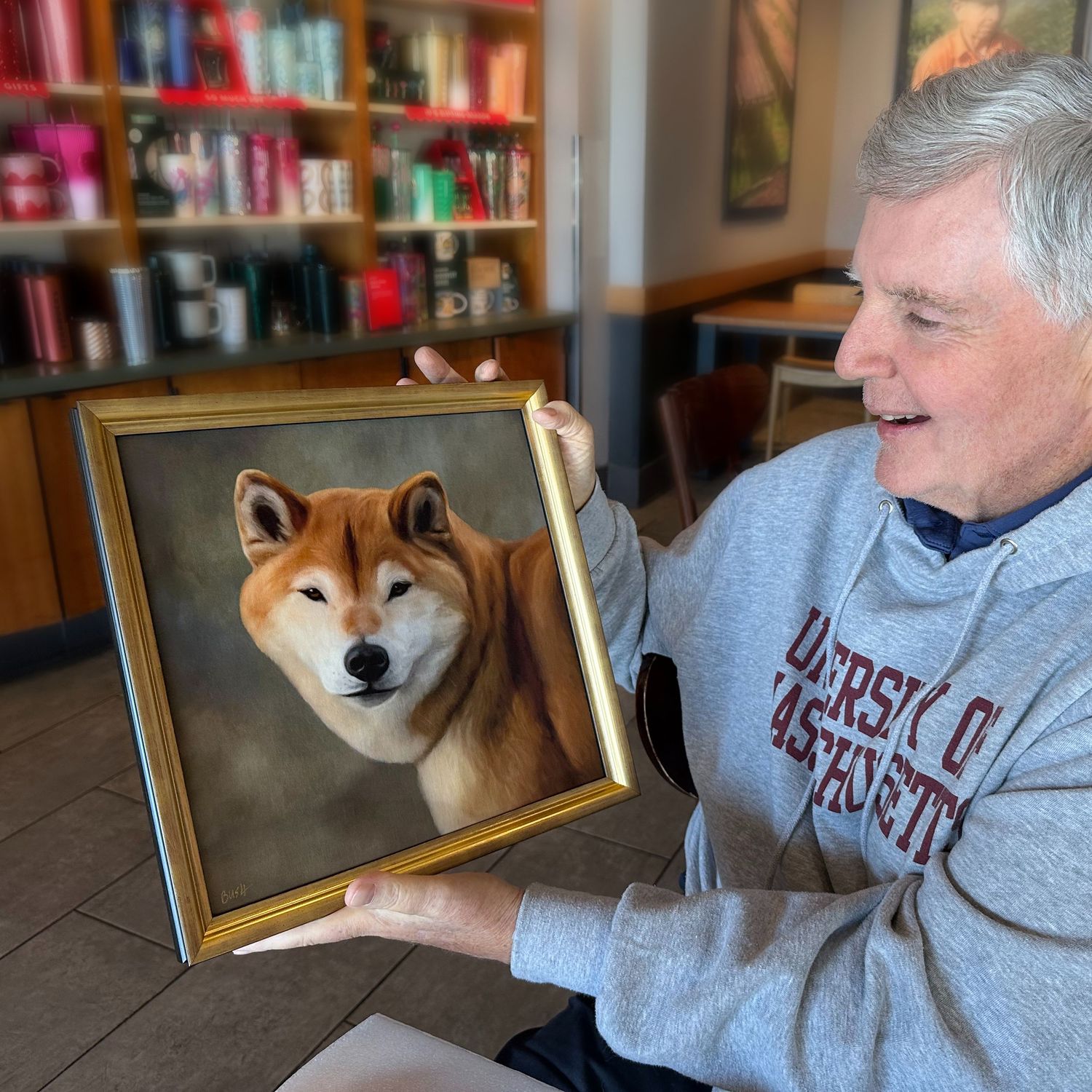 A client excited to see the finished framed memorial pet portrait painting of his beloved a Shiba Inu dog.