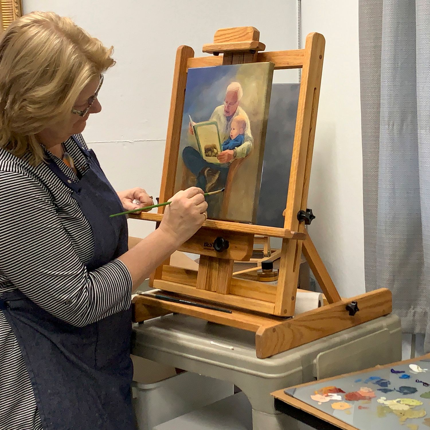 Artist working on a commissioned painting at a wooden easel in a studio setting.
