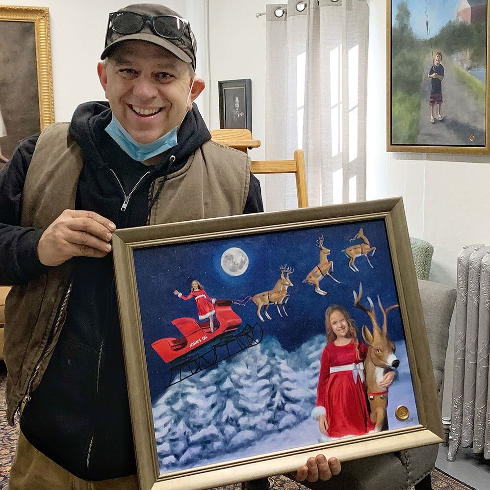 Happy client proudly displaying the custom artwork of his daughter in Santa's sleigh flying over snowy mountains at night.
