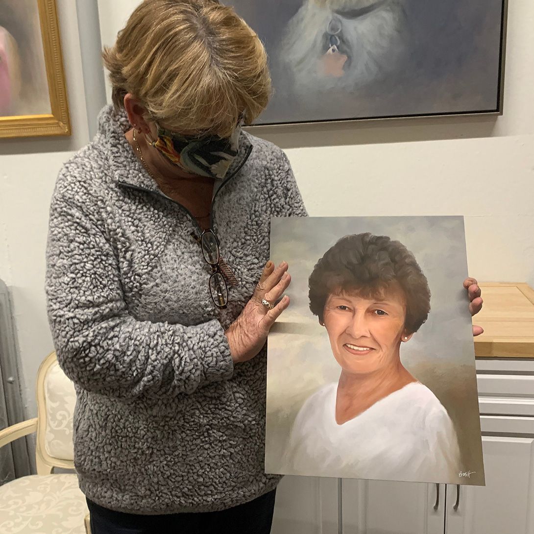 A client admiring her mother's portrait painting at the unveiling.