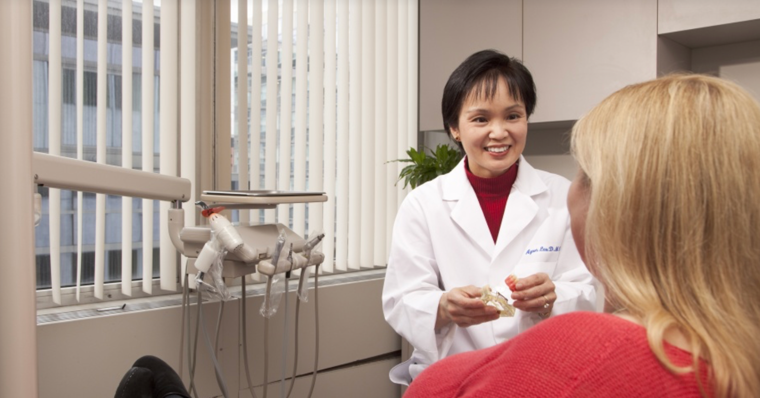 Original source photo of a physician in her office with a patient, used as a source photo for a special painting commission.