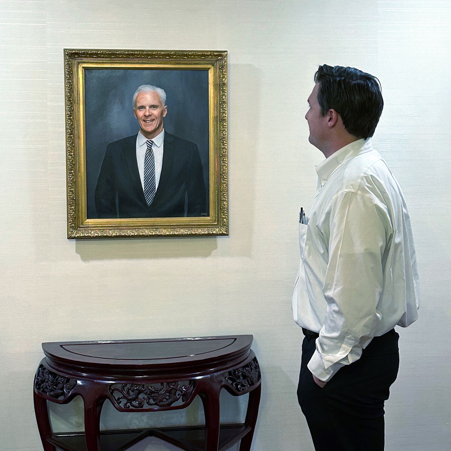 Admiring the finished framed memorial portrait painting at Murphy Funeral home on the wall in their lobby.