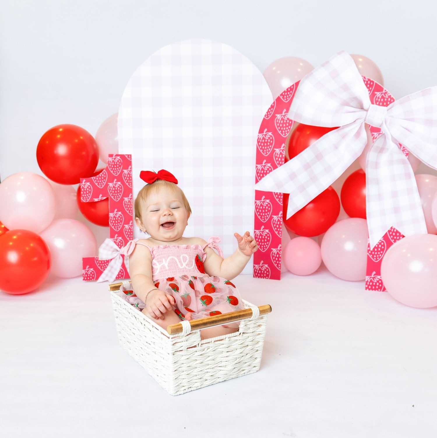 Baby laughs while sitting in basket for strawberry themed 1st birthday shoot with Annie Robinson Photography of Pittsburg KS and Joplin Mo.