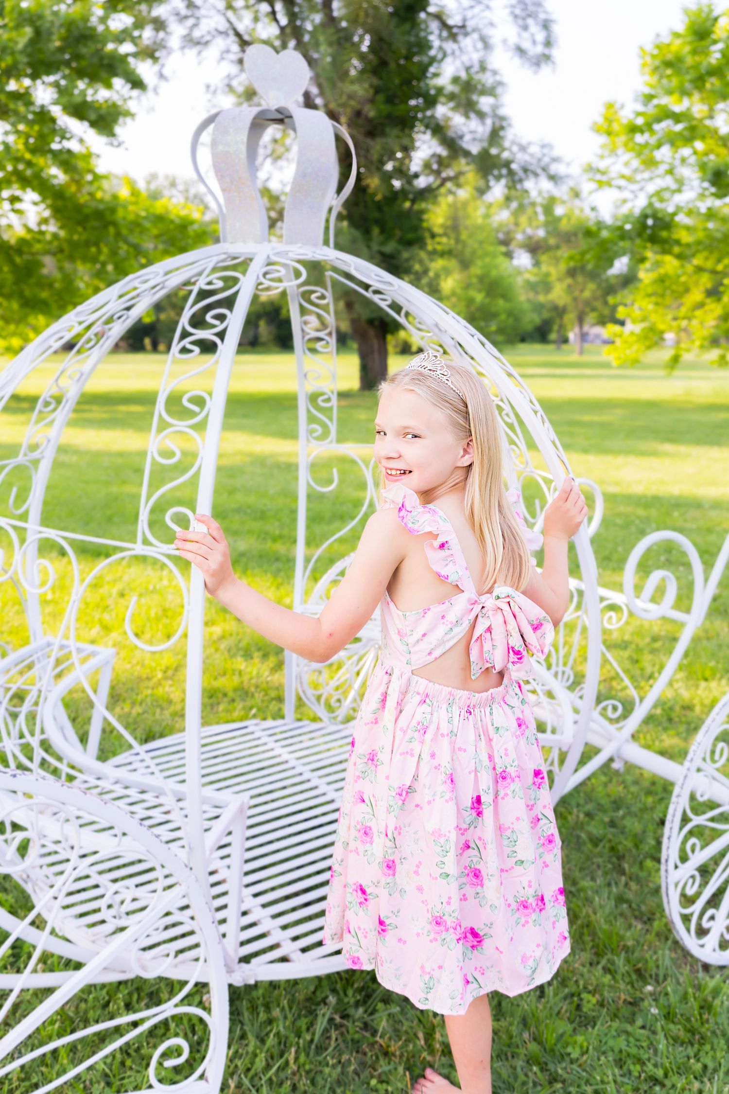 A young girl steps into a large white carriage during a princess mini session photoshoot in Pittsburg Kansas.