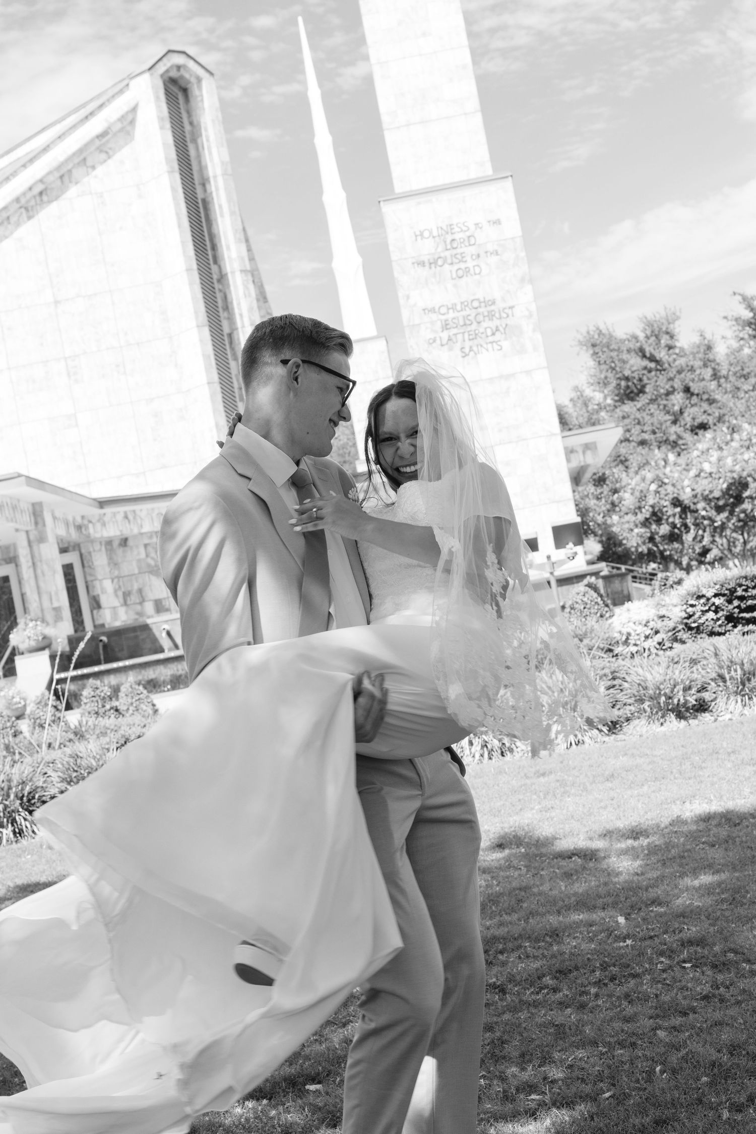 A bride and groom spin around in front of the Latter Day Saints temple in Dallas, Texas.