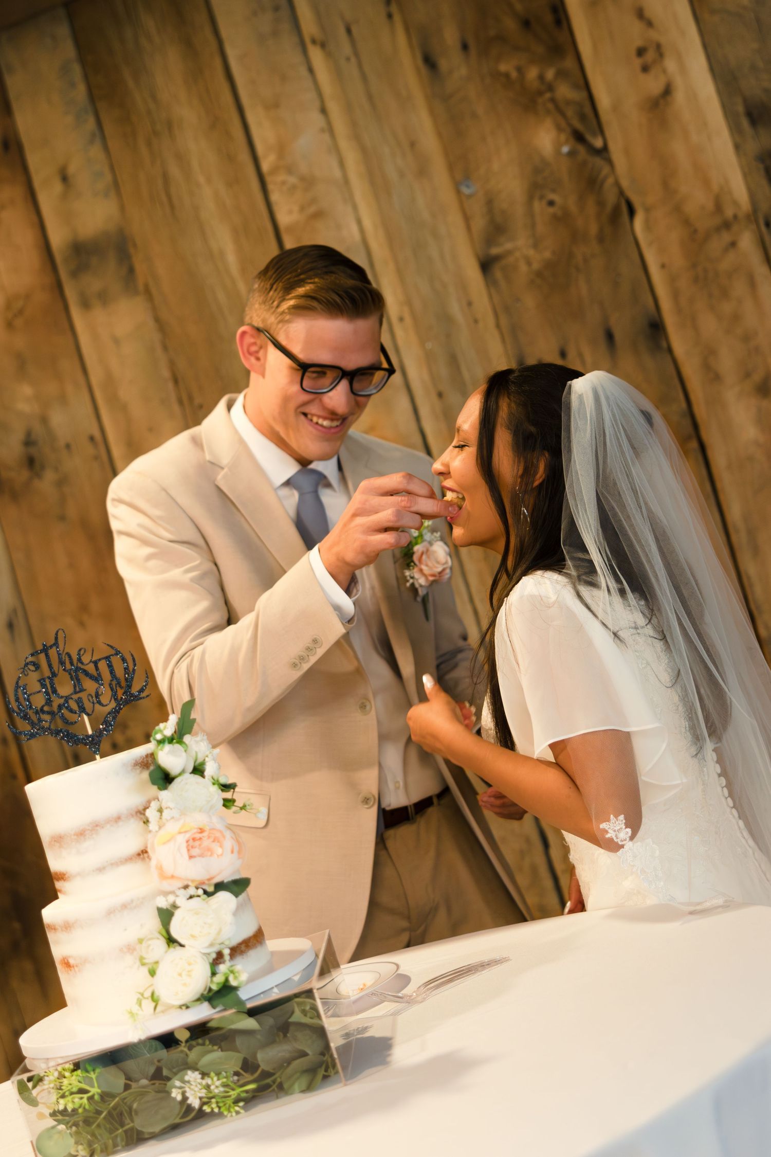 A groom feeds his bride wedding cake at their wedding reception in Texas.